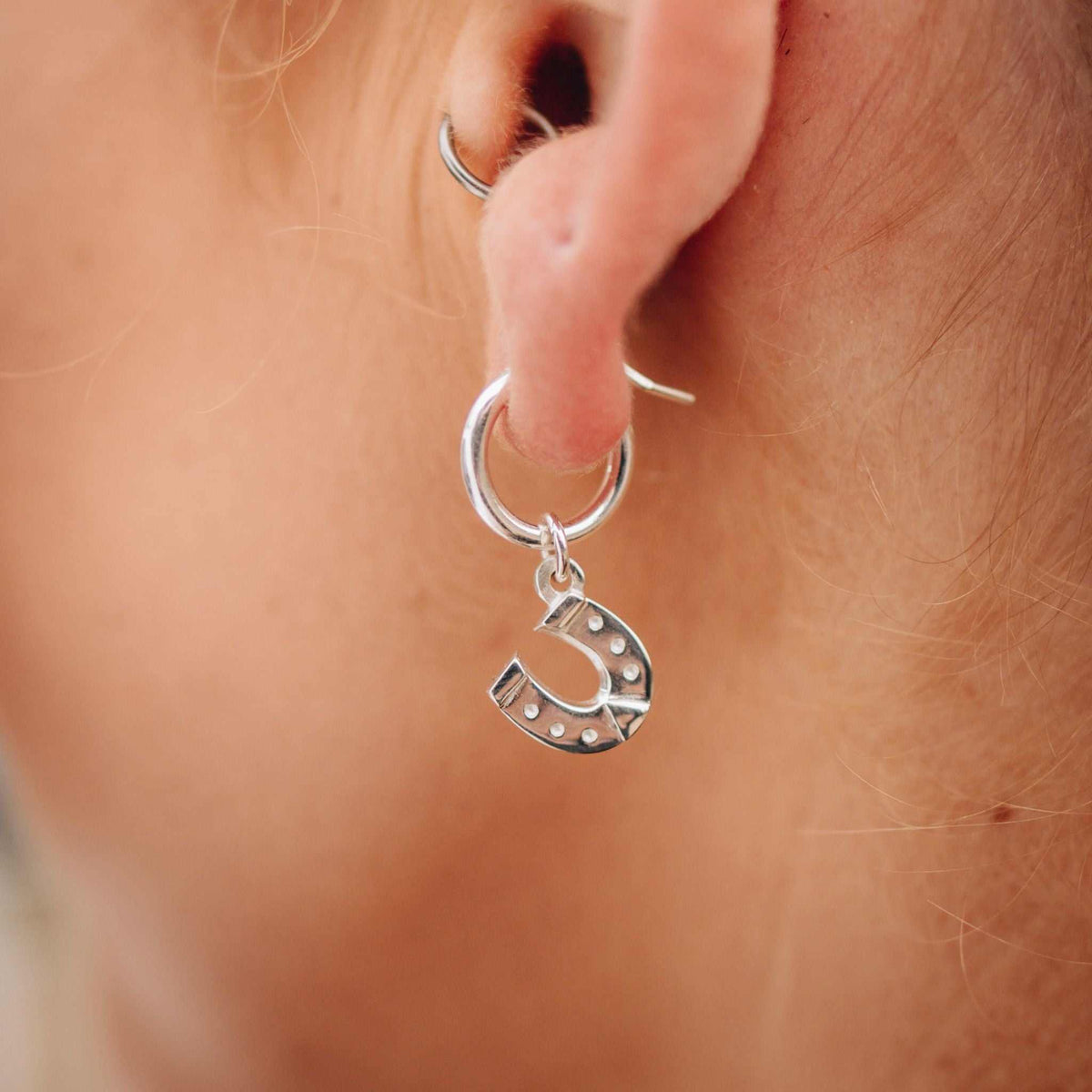 Sterling silver equestrian earrings flat lay product shot - handcrafted horse rider jewellery New Zealand. Horseshoe.