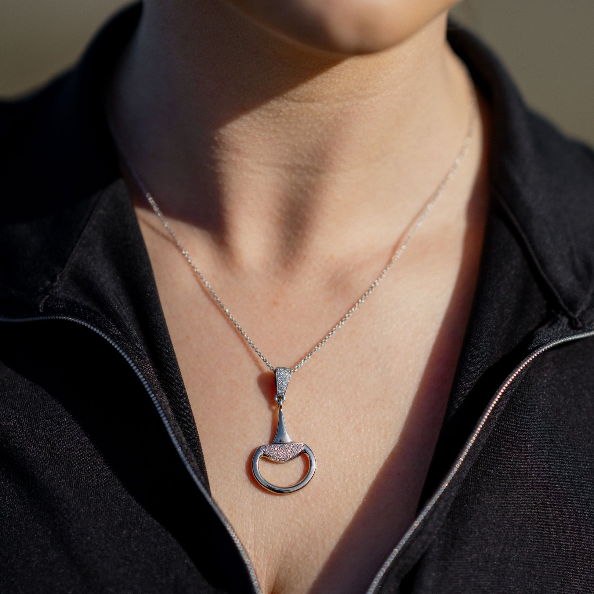 Equestrian horse rider wearing a white gold diamond set half snaffle pendant by Crawford Hill Equestrian Jewellery.