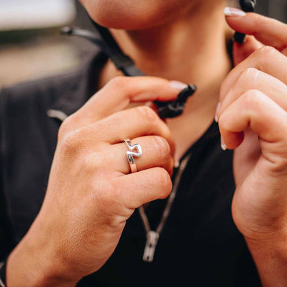 Equestrian Ring in polished silver with a sculptural stirrup-shaped design, worn on a finger as a contemporary equestrian accessory