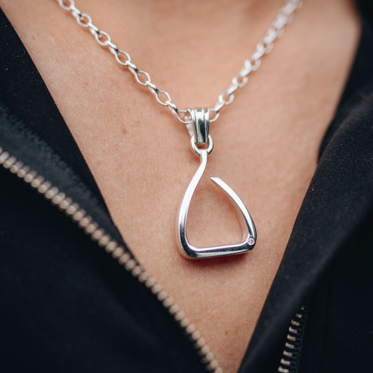 Silver jump stirrup necklace. Set with one diamond. Based on the Freejump Stirrup. This is for Horse riders and equestrians. Made by Crawford Hill Equestrian Jewellery.