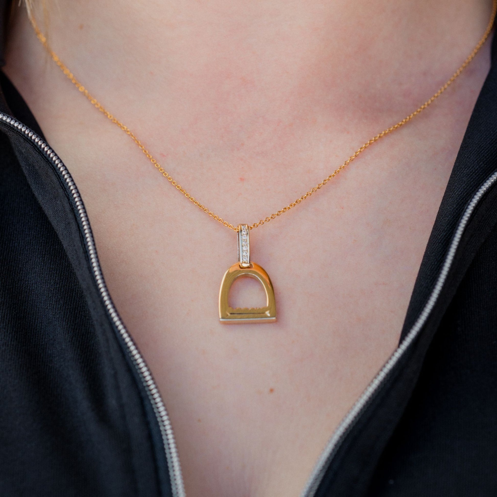 Small silver stirrup necklace with white diamonds set into the bale. Worn by ahorse rider by Crawford Hill Equestrian Jewellery.