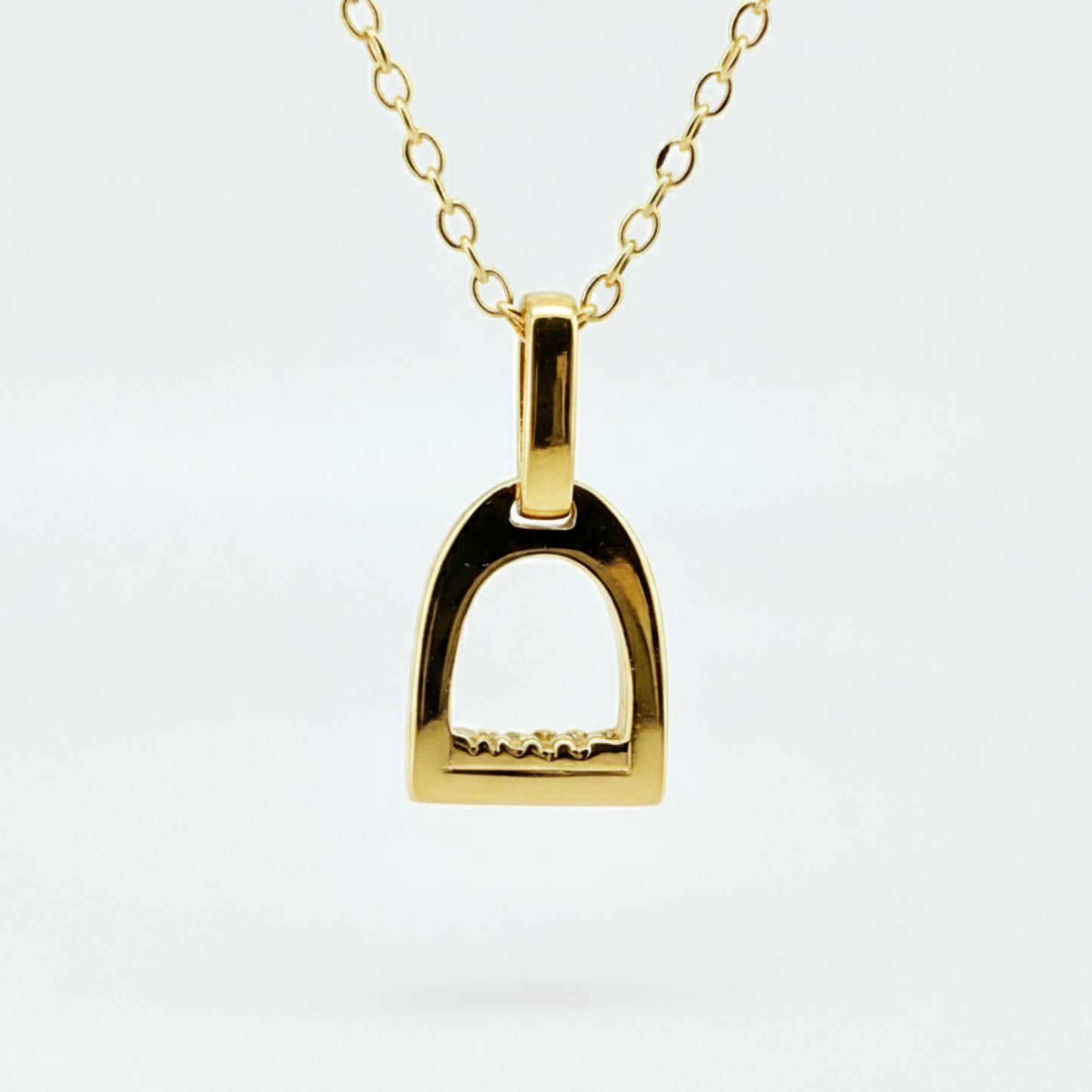 Product photo of small yellow gold stirrup necklace. Made to be worn by horse riders by Crawford Hill Equestrian Jewellery.