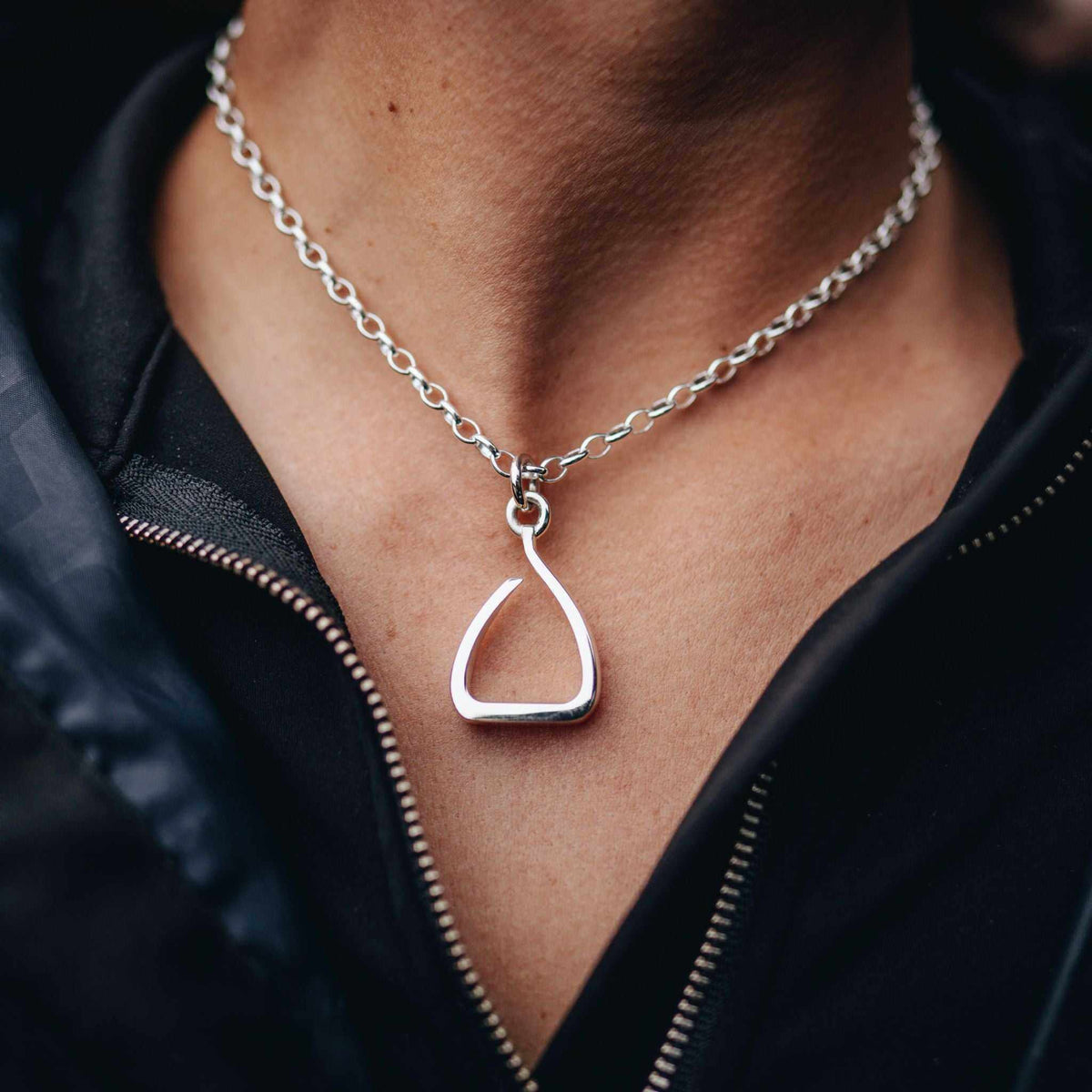 Stirrup Pendant in polished sterling silver with a sculptural open stirrup shape, worn on a silver chain